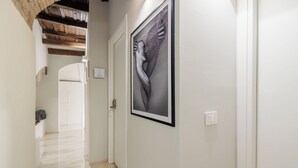 A hallway with a marble floor, a framed artwork on the wall, and a door at the end. - SOHO Fontana Grande By Dasso (Viterbo)