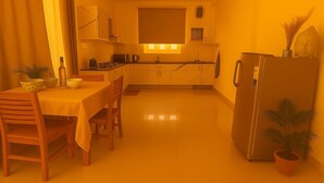 Eine kompakte Küche mit Essbereich, ausgestattet mit Kühlschrank, Spüle und Herd.