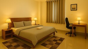 Ein ordentlich eingerichtetes Schlafzimmer mit Bett, Nachttischen, Schreibtisch und Stuhl.