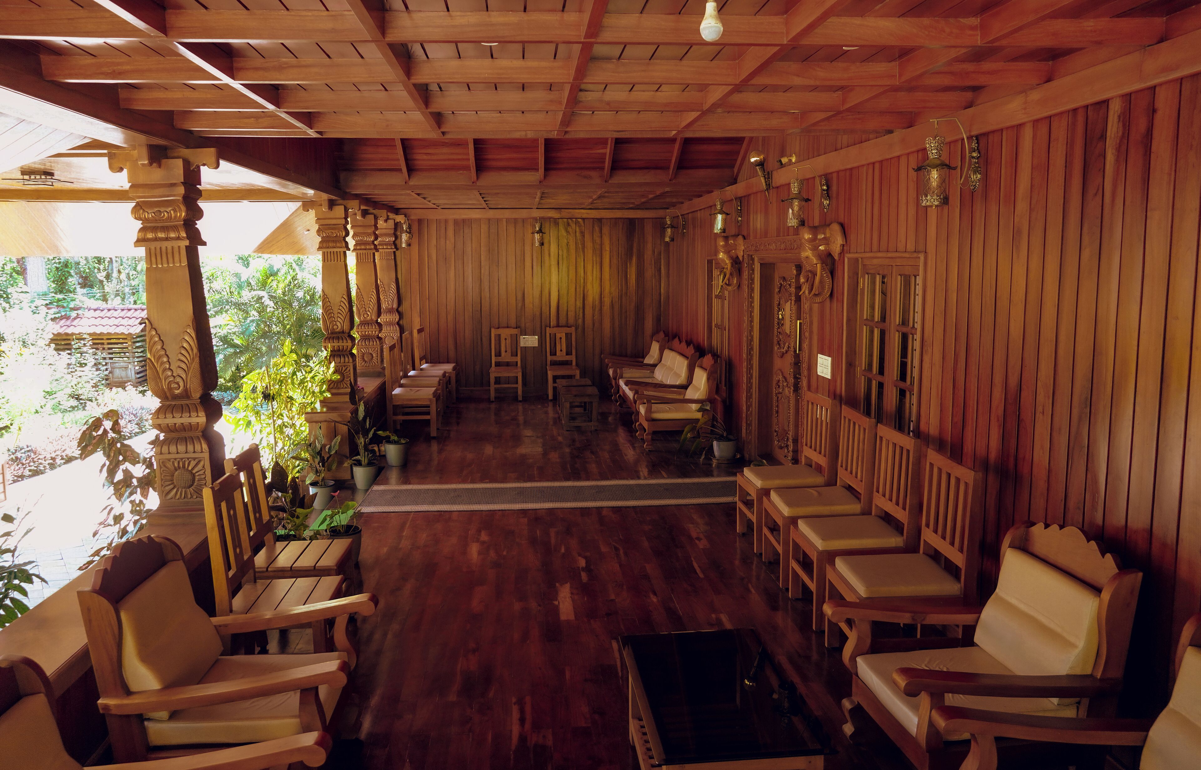 A wooden interior with a long bench area and a view of the outdoors.