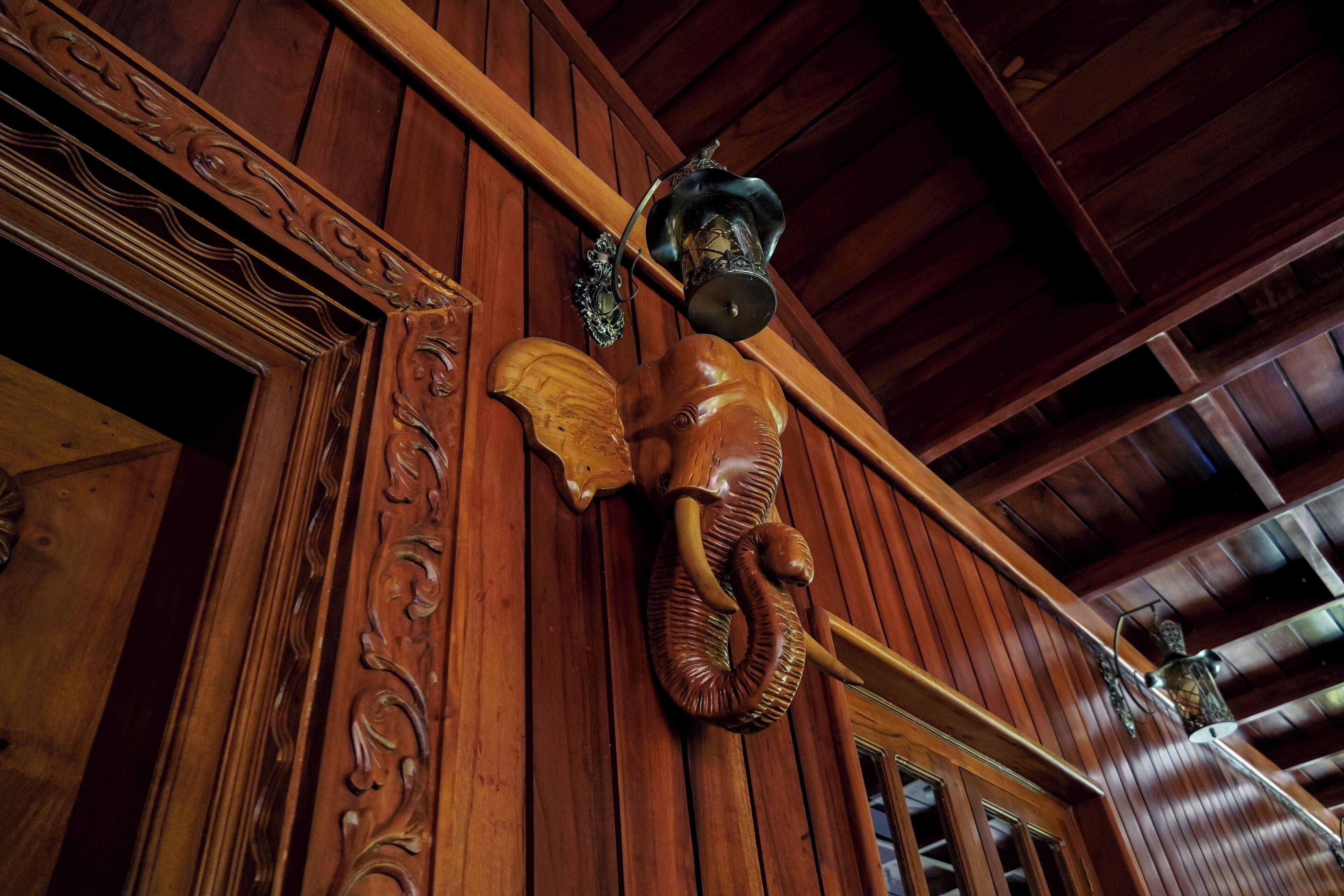 A wooden interior with carved wooden panels and a decorative lantern.