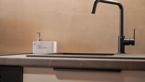 A kitchen sink with a faucet and a soap dispenser labeled "KITCHEN". - Aphrodite Suite by Acropolis Luxury Athens Suites (Athens)