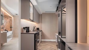 A modern kitchen with a central island, built-in appliances, and a herringbone wood floor. - Aphrodite Suite by Acropolis Luxury Athens Suites (Athens)