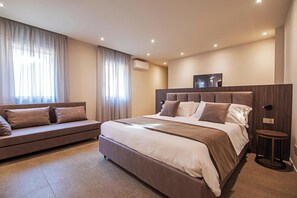 Un dormitorio moderno con una cama grande, un sofá y una mesita.