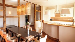 Una cocina moderna con vigas de madera, una isla central e iluminación colgante.