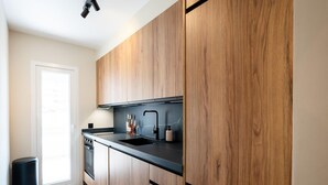 Eine moderne Küche mit Holzschränken, einer schwarzen Arbeitsplatte und einem eingebauten Geschirrspüler.