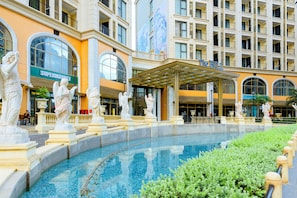 A hotel with a pool, statues, and a supermarket. - Mira Home Apartment Hillside Phu Quoc (Phu Quoc)