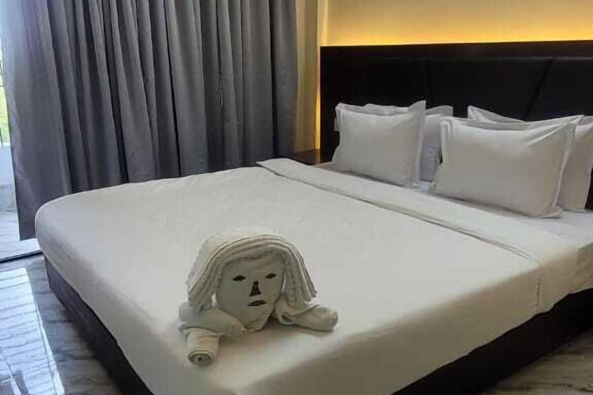 Une chambre d’hôtel avec un grand lit, une tête de lit et un sol en marbre.