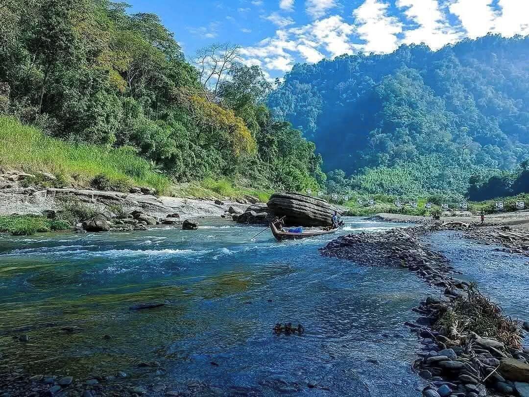 Un río de aguas cristalinas, rodeado de vegetación y rocas.