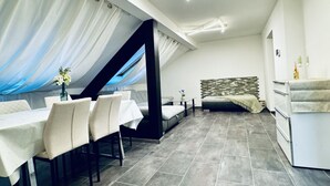 Een modern interieur met een eethoek, een bank, een bed en een keuken.