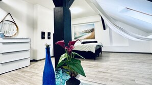 Een moderne slaapkamer met een bed, een bureau en een groot raam.