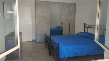 Een slaapkamer met een bed, een kledingkast en een spiegel.
