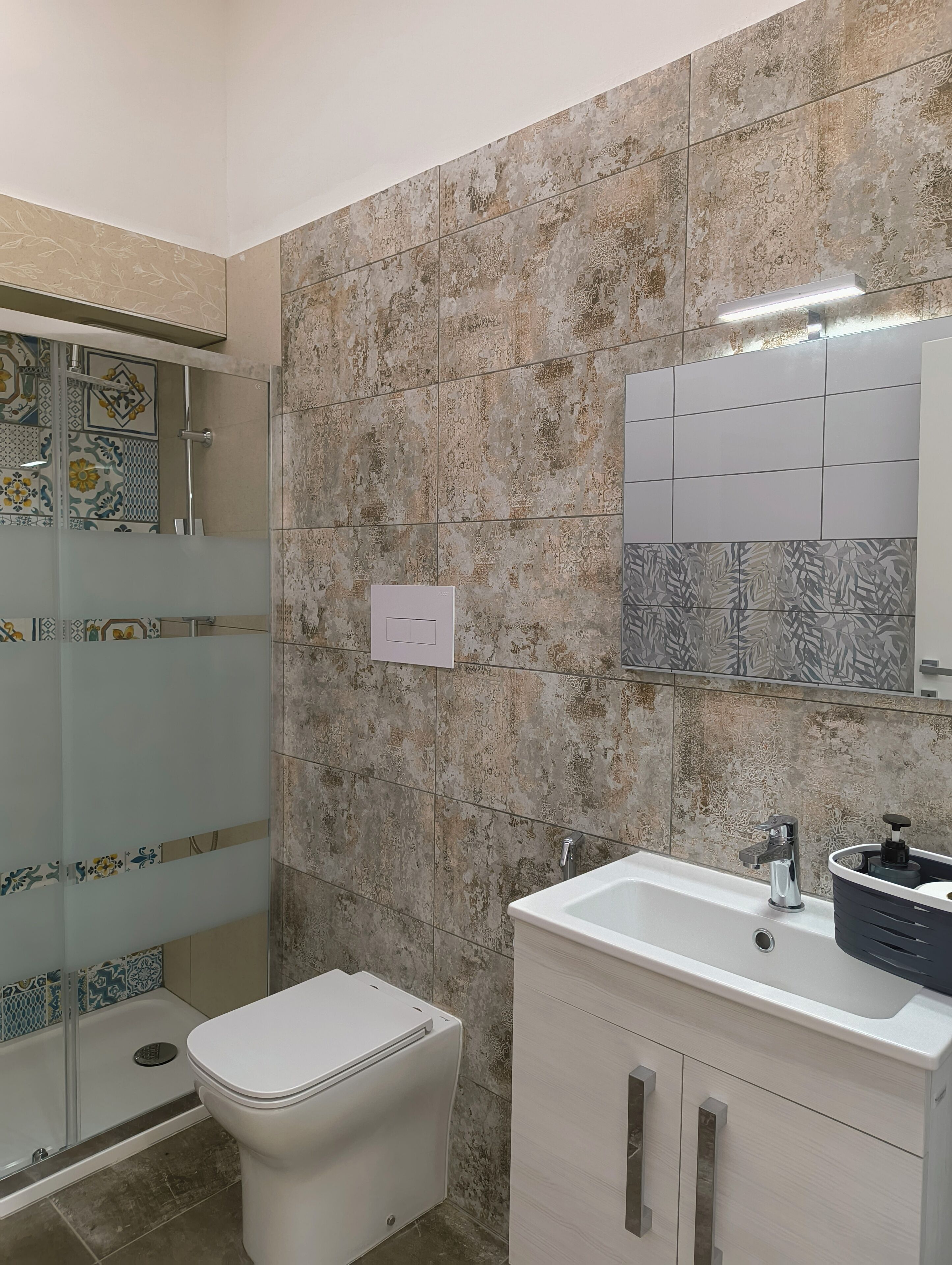 Ein Badezimmer mit Dusche, Toilette und Waschbecken.