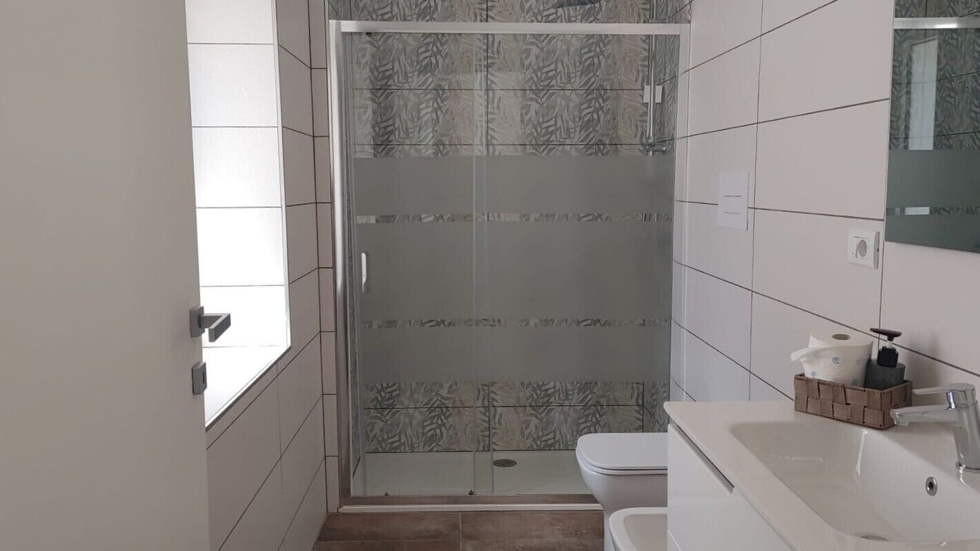 Un baño con ducha, inodoro y lavamanos.