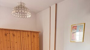 A bedroom with a wooden bed, a blue bedspread, and a wooden wardrobe. - Sole d'Otranto, independent apartment in Otranto (punta area) 500m from the sea (Otranto)