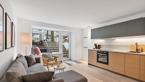 Un appartement moderne comprenant un salon, une cuisine et une porte-fenêtre coulissante donnant sur un balcon.
