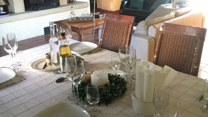 A dining area with a table set for a meal, a fireplace, and a sofa in the background. - Spacious gîte in idyllic wooded setting by a stream with hammock & barbecue (Cronat)