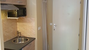 A compact kitchen with a sink, microwave, and a small refrigerator. - Studio in residence near Lourdes / Vallée des Gaves (Aspin-en-Lavedan)