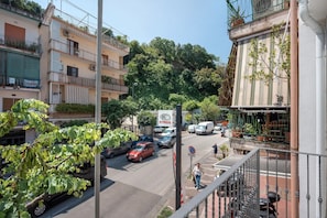 Une vue de rue avec des immeubles, des voitures garées et un passage piéton.
