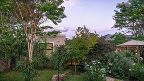 Ein Garten mit verschiedenen Pflanzen und einer Ziegelmauer.