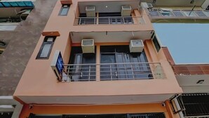 A multi-story building with balconies, air conditioning units, and a blue awning. - Star Light Inn (New Delhi)