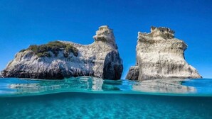 Vista despejada de dos formaciones rocosas en un mar turquesa, sin estructuras ni personas a la vista.