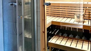 Une salle de bain moderne dotée d’une douche à parois de verre, d’un plafond en bois et d’un meuble-bar intégré.