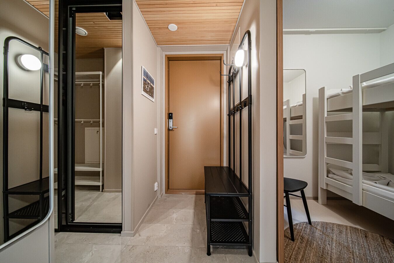 Un couloir avec un plafond en bois, une porte, un banc et un miroir.