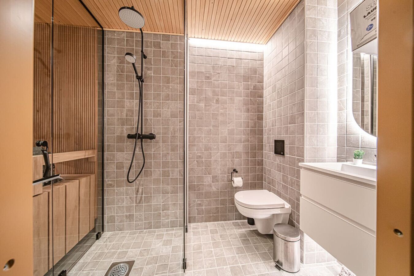 A modern bathroom with a shower, toilet, and sink.