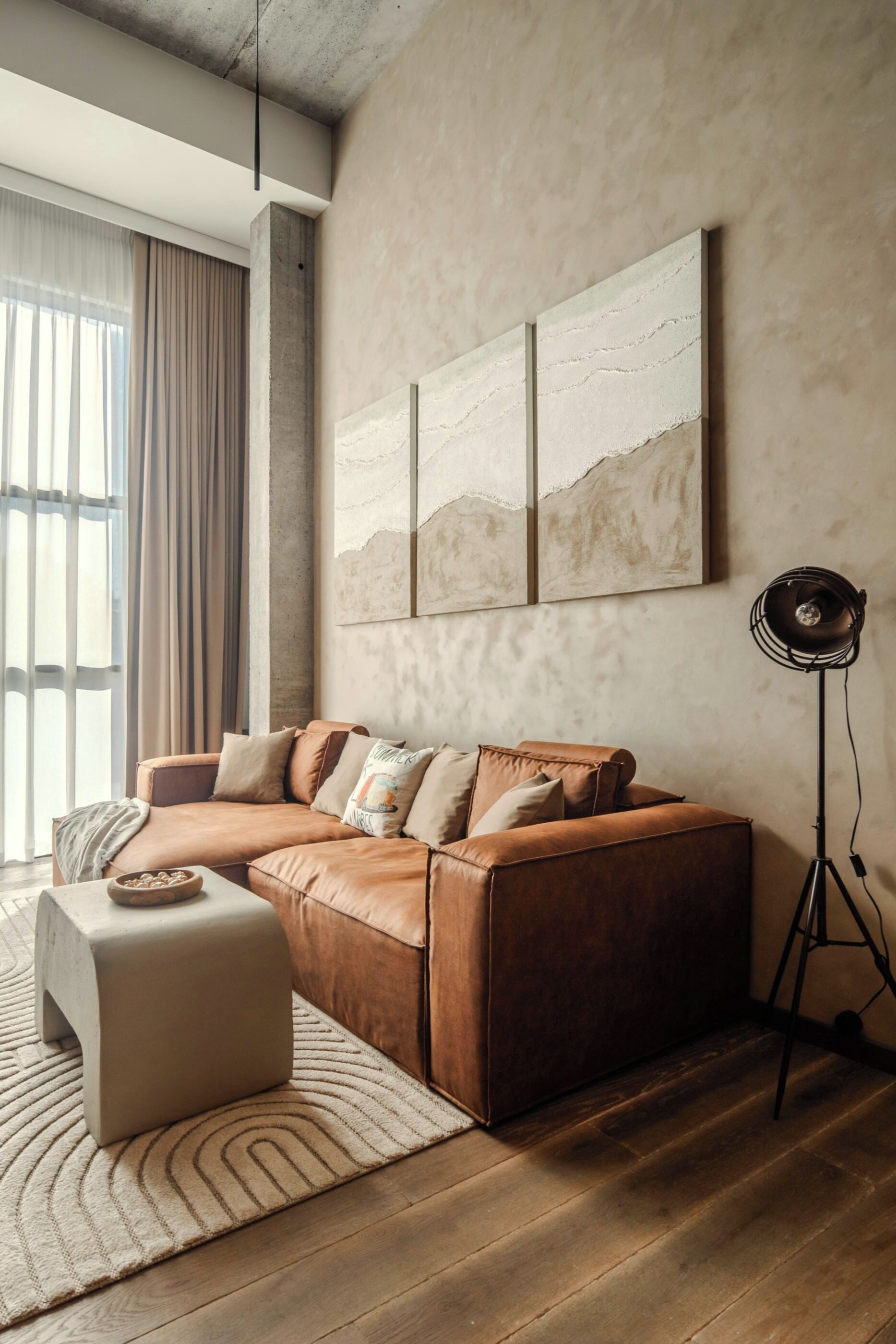 Een moderne woonkamer met een hoekbank, een klein bijzettafeltje en een vloerlamp.