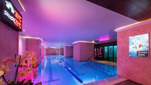 A swimming pool with a temperature display, surrounded by pink walls and purple lighting. - Rusty Wave Loft in the heart of Klaipeda (Klaipeda)
