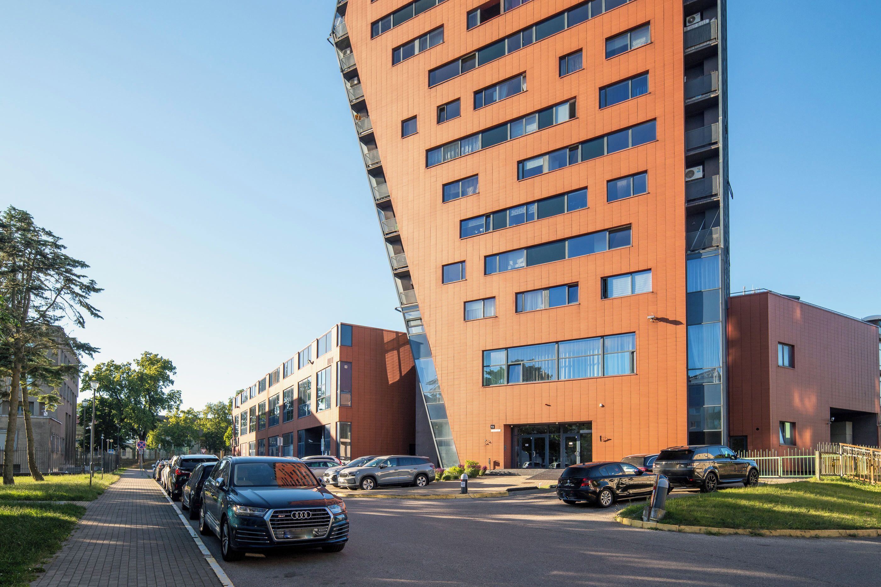 A modern building with a unique angular design, featuring multiple floors and large windows.