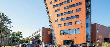 A modern building with a unique angular design, featuring multiple floors and large windows.