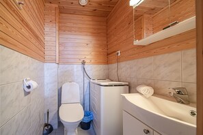 A compact bathroom with a toilet, bidet, and sink.