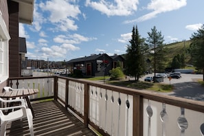 A balcony with a view of a parking lot and a building with a sign that reads 'ZERO POINT'.