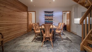 Ein Essbereich mit Holztisch und -stühlen, einer Wandteppich und einer Treppe.