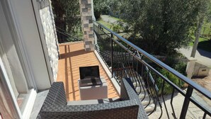 A balcony with a small table and a laptop, surrounded by a metal railing and a stone wall. - Casa dos Fetos - Rural vacation home in Portugal (Espite)