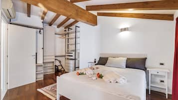 Une chambre à coucher comprenant un lit, des tables de chevet, une armoire et une étagère intégrée.