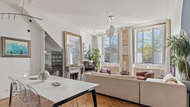 A spacious living area with a large sofa, a dining table with chairs, and a fireplace. - On a southern quay of the Île Saint Louis. Like a house. Close to Notre-Dame. (Paris)