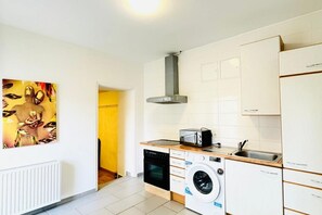 Een magnetron, een oven, een kookplaat, kookgerei, borden en bestek