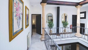 A spacious interior with a high ceiling, a balcony with a railing, and a view of the outside. - Hotel Boutique Palacio de la Duquesa (Ronda)