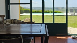 A room with a large sliding glass door leading to a grassy outdoor area. - Casa do Moinho, between the Lagoon and Óbidos Castle (Óbidos)