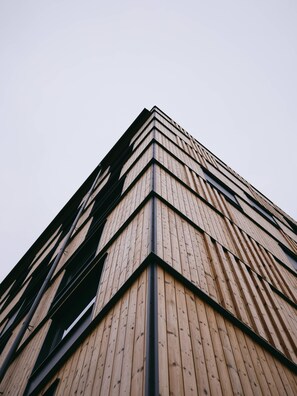 A modern building with a wooden facade and black structural elements.