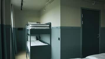 Een slaapkamer met een stapelbed, een deur en een raam.