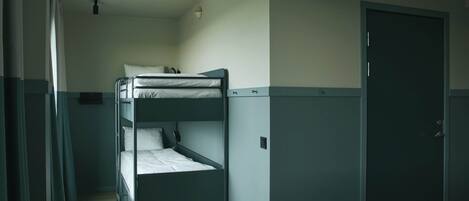 Une chambre avec un lit superposé, une porte et une fenêtre.