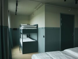 Habitación con literas, una puerta y una ventana.