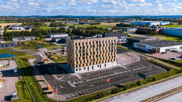 A modern building with a parking lot and a river in the background.