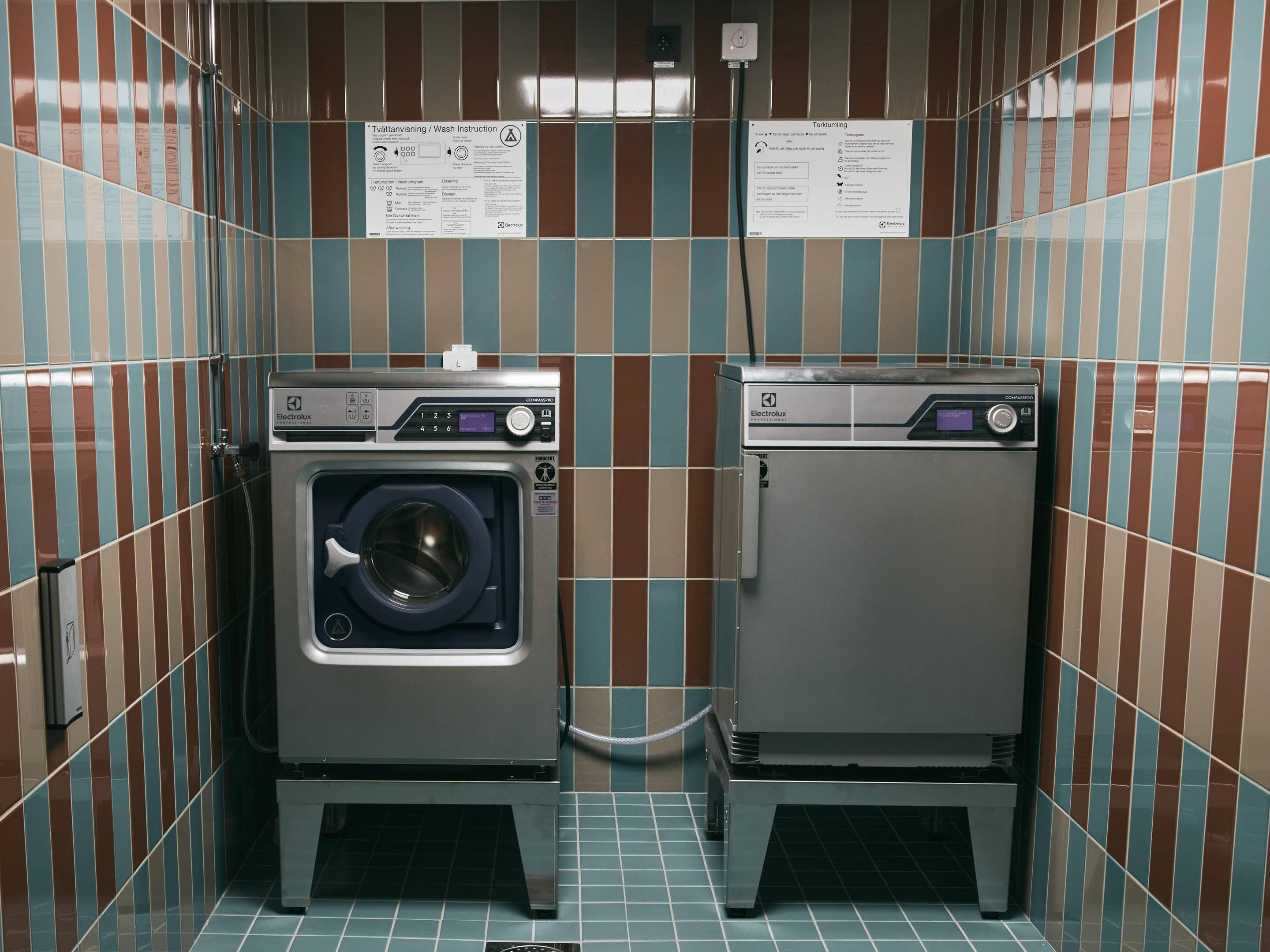 A compact laundry facility with two washing machines and drying machines, each with a digital display and control panel.