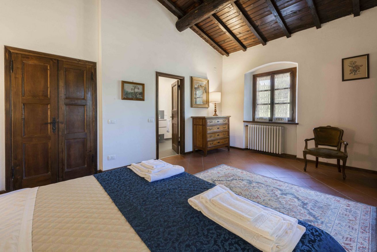 Un dormitorio con cama, cómoda, silla y ventana.