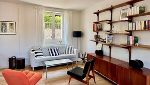 A modern living room with a sofa, coffee table, and a bookshelf.